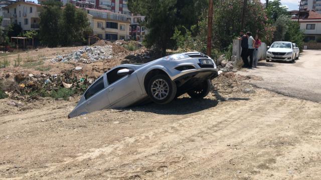 Adana'da yol kenarında askıda kalan araçtaki 3 kişi yara almadan kurtuldu